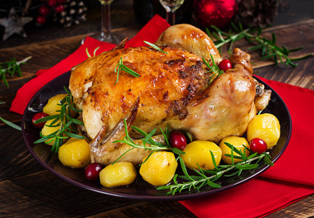 Baked chicken or baked turkey. The Christmas table is served with a turkey. Fried chicken, table setting. Christmas dinner.の写真素材