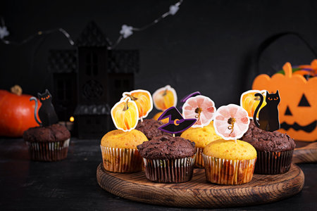 Festive Halloween cupcakes and treats decorated with funny stickers. Halloween muffins. Chocolate muffinsの写真素材