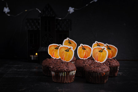 Festive Halloween cupcakes and treats decorated with funny stickers. Halloween muffins. Chocolate muffinsの写真素材