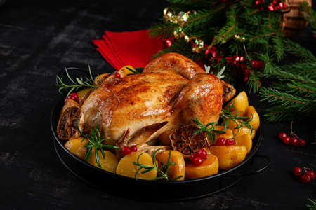 Roasted chicken with potatoes and Christmas decoration. Table setting. Baked chicken or turkey. Close Upの写真素材