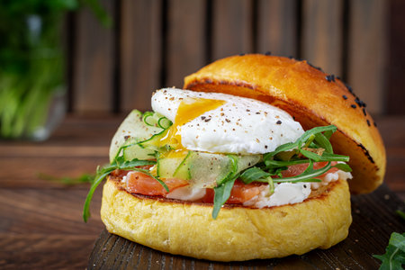Bun breakfast sandwich with salt salmon, cream cheese and poached eggの写真素材
