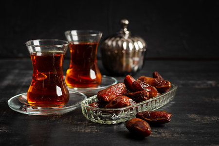 Ramadan food and drink concept. Tasty Eastern sweets and tea on dark background.の写真素材