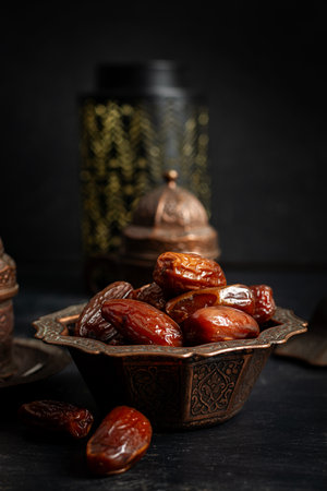 Ramadan food and drink concept. Tasty Eastern sweets and tea on dark background.