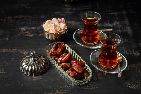 Ramadan food and drink concept. Tasty Eastern sweets and tea on dark background.の写真素材