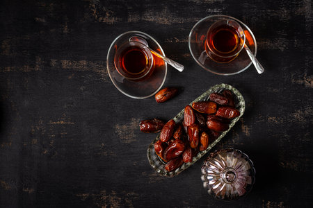 Ramadan food and drink concept. Tasty Eastern sweets and tea on dark background.の写真素材