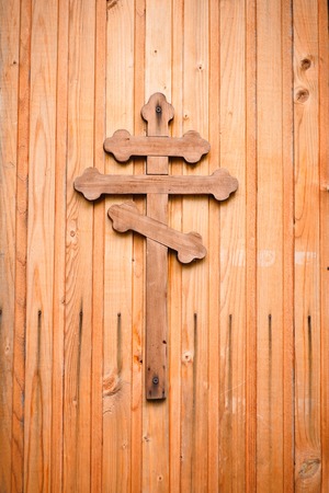 Wooden cross with silver detail representations of the Crucifixion on green backgroundの写真素材