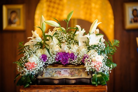 Wedding accessories and interior in Saint Trinity Orthodox Convent including two candlesticks with many candles, flowers, icons and Holy Bible. Wonderful church in Riga, Latviaの写真素材