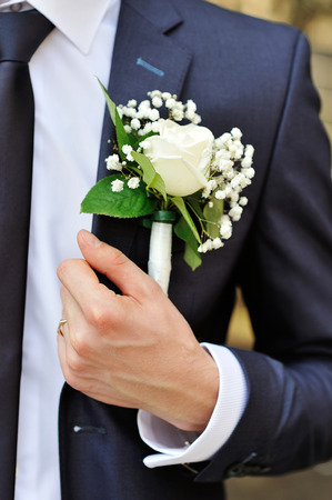 white rose boutonniere on suit of the groomの写真素材