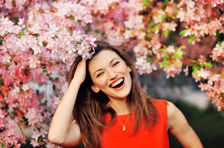 beautiful young girl on a background of flowering treesの写真素材