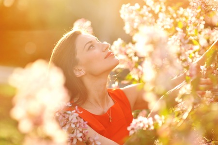 portrait of young lovely woman in spring flowers.の写真素材