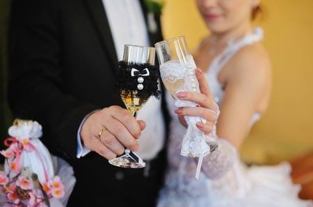 bride and groom holding beautiful wedding champagne glasses.の写真素材