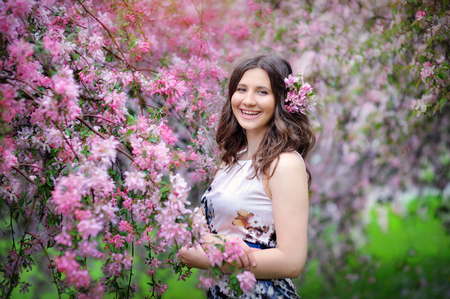 Beautiful woman walking in blossoming spring gardenの写真素材