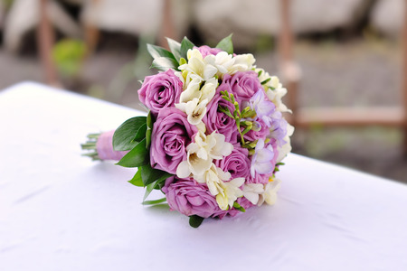 Bridal bouquet of purple roses on tableの写真素材