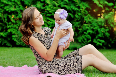 Beautiful Mother And Baby playing in a park. outdoors. Nature. Beauty Mum and her Child playing...