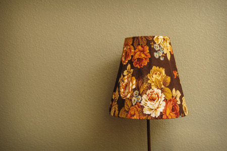 vintage Bedroom floor lamp glowing orange in a corner of a roomの写真素材