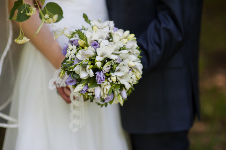 Wedding bouquet in hands of the bride and groomの写真素材