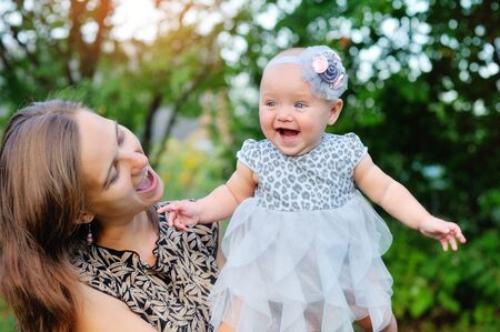 Happy mother and daughter smiling outdoors in a parkの写真素材