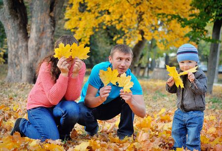 Happy beautiful family relaxing in autumn park.の写真素材