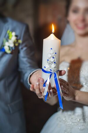 Candle bride and groom holding hands.の写真素材