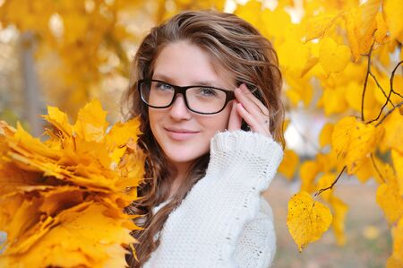 Beautiful girl with glasses in autumnの写真素材