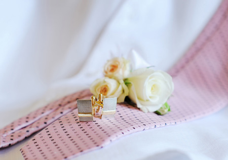 Wedding rings, cufflinks tie on the couch.の写真素材