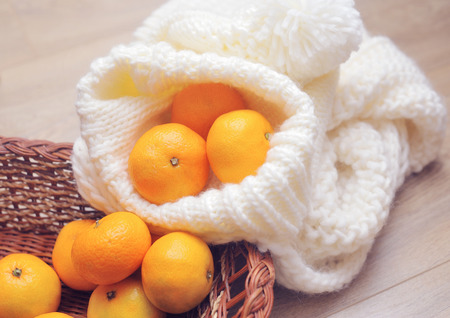 Christmas tangerines and Christmas toys on knitted scarf close-up.の写真素材