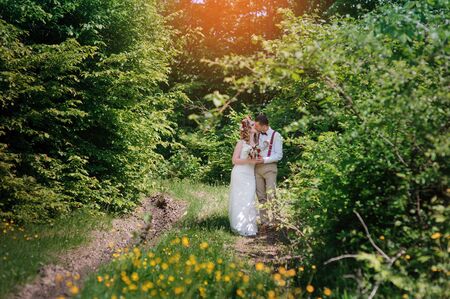 happy bride and groom standing near to the road and huggingの写真素材