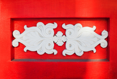 beautiful white architectural relief pattern on red background.の写真素材
