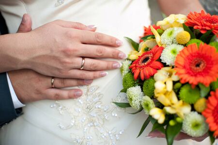 groom embraces the bride, the bride holds a wedding bouquet.の写真素材