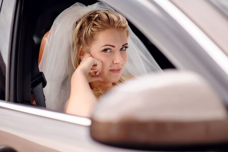Bride blonde in a wedding car.の写真素材