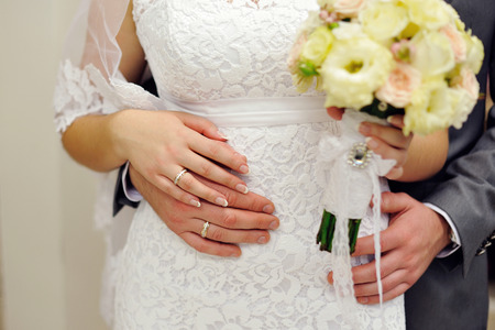 hands of the bride and groom with wedding rings.