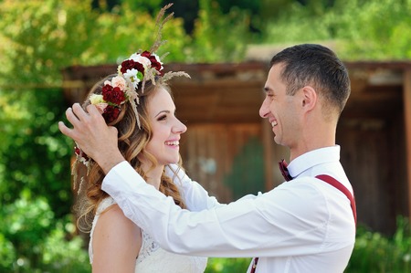 groom wears a wreath of flowers on the bride's headの写真素材