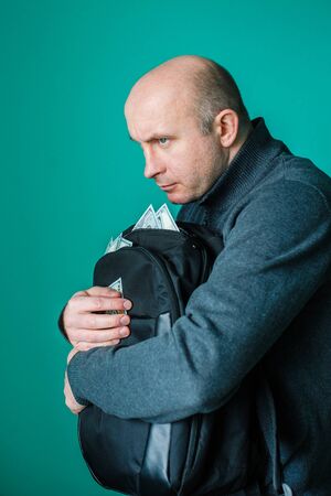 greedy man holding a black bag of money.の写真素材