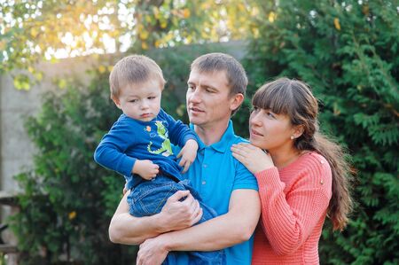 Happy family on walk in autumn park.