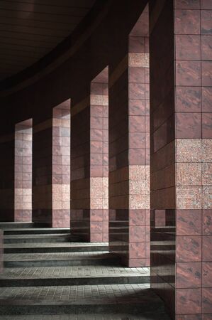 Row of columns with sunlight in the gaps and reflected in shiny floor.の写真素材