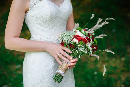 bride holding a wedding bouquet of wildflowers.