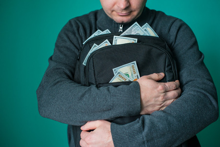 excited businessman holding black bag with money.