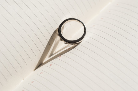 wedding ring is on the page diary and makes a shadow in the form of heart.の写真素材