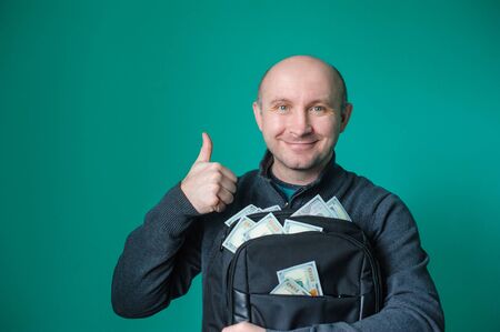 man holding a black briefcase with dollars.