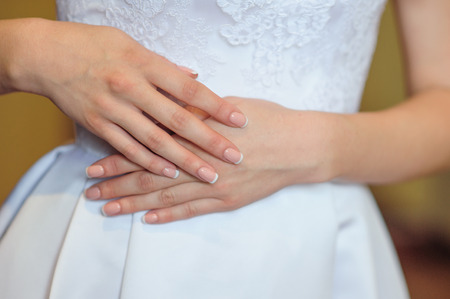 hands of a bride with a wedding manicure.の写真素材