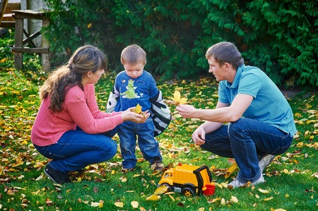 father, mother and young son at a picnic in the park.