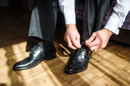 Business man tying shoe laces on the floor. Close-up.の写真素材