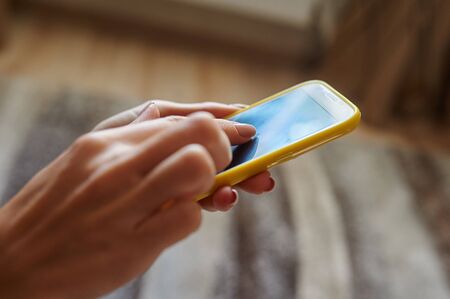 Closeup woman hand typing on smart phone.の写真素材