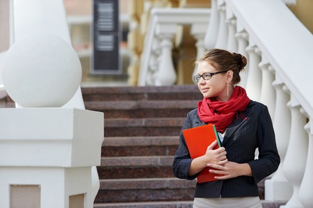 Closeup portrait of pretty young student girl holding exercise books and folder.の写真素材