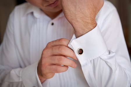 close up of a hand man how wears white shirt and cufflink.の写真素材