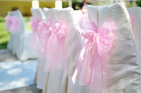 beautiful chairs with pink bows on wedding ceremonyの写真素材