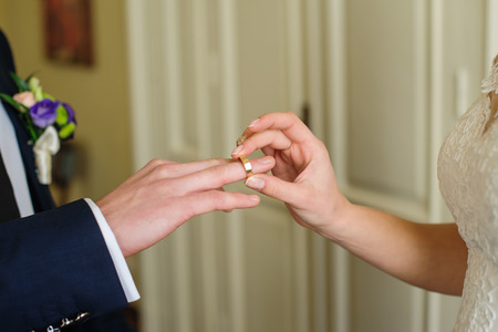 Bride groom puts the ring on his hand on the wedding day.の写真素材