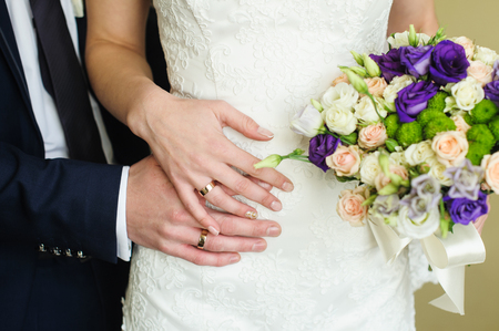 Wedding rings on the hands of the bride and groom.の写真素材