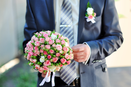 groom is holding a wedding bouquetの写真素材