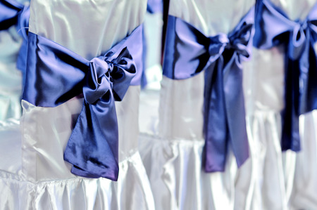 The chairs are decorated with purple bowsの写真素材